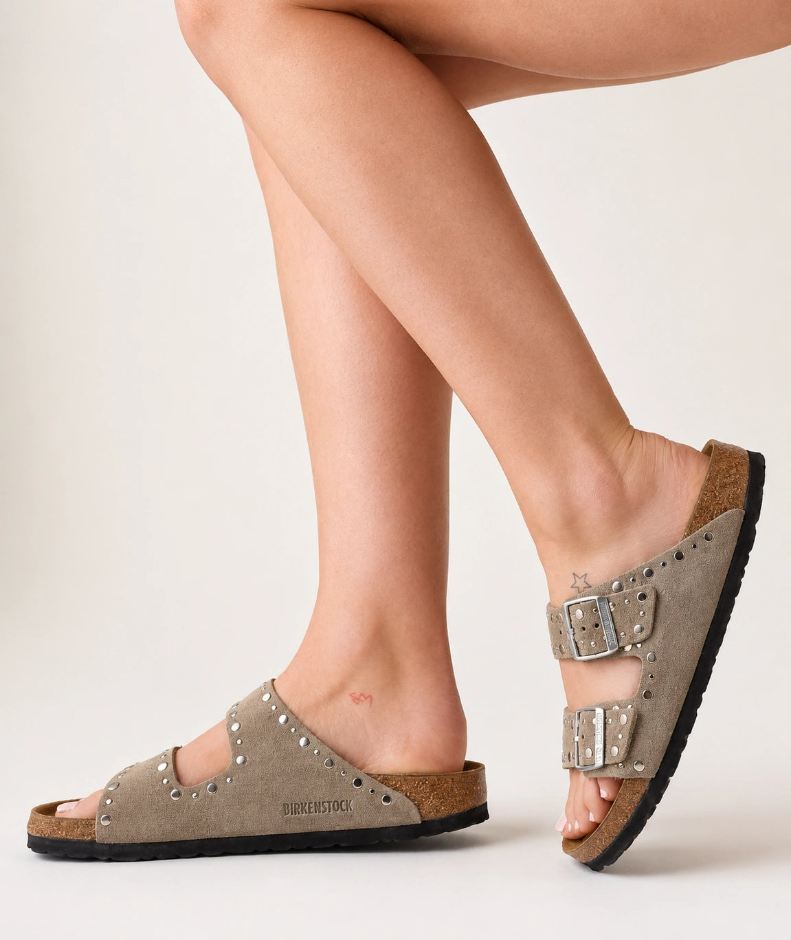 Birkenstock Arizona Rivets Sandals in Taupe suede worn on foot, showing silver-tone rivets and branded buckles
